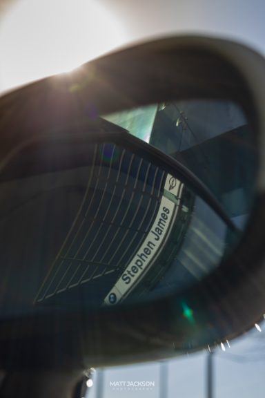 Reflection in a rear-view mirror with sunlight filtering through.