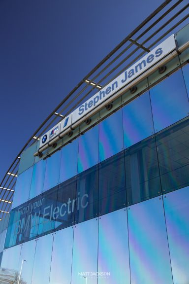 Exterior of a modern building with reflective glass and signage for "Electric".